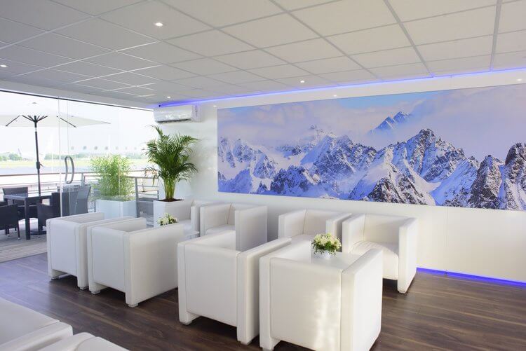 Chairs inside a chalet at an air show with a mountain range background