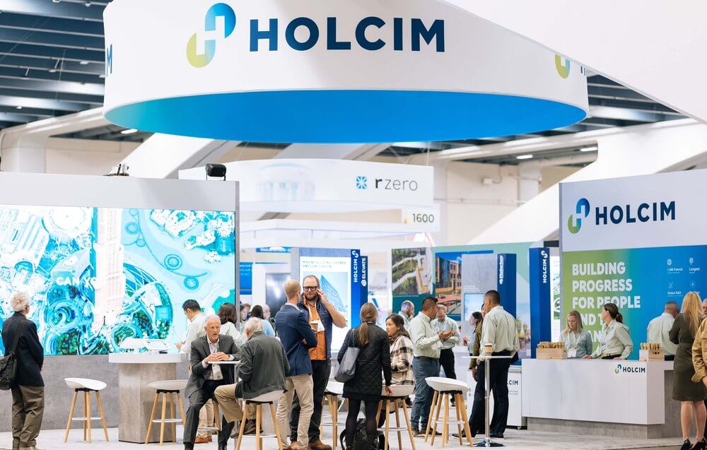 Holcim wide shot people talking at exhibition