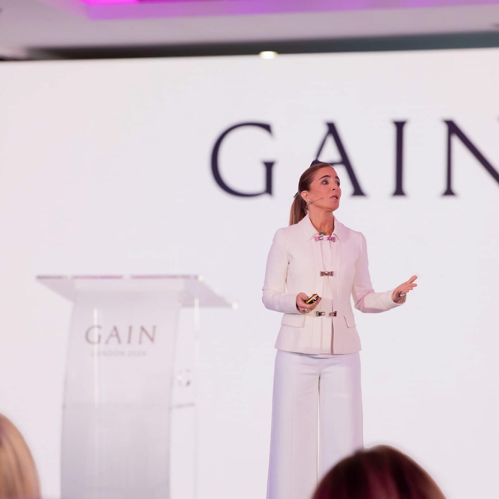 Women talking with GAIN logo behind her at event
