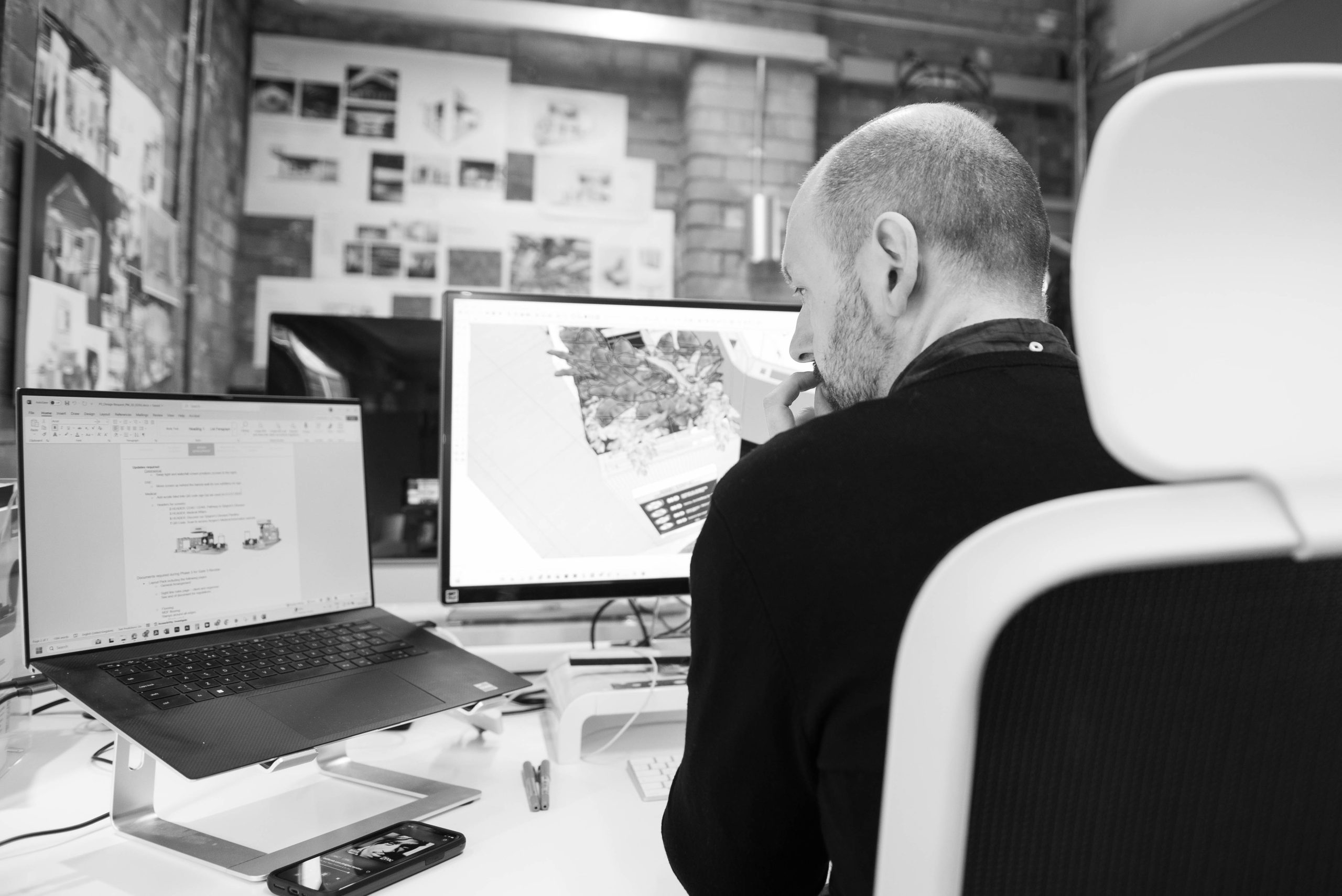 Gabri looking over designs on his 2 screened computer