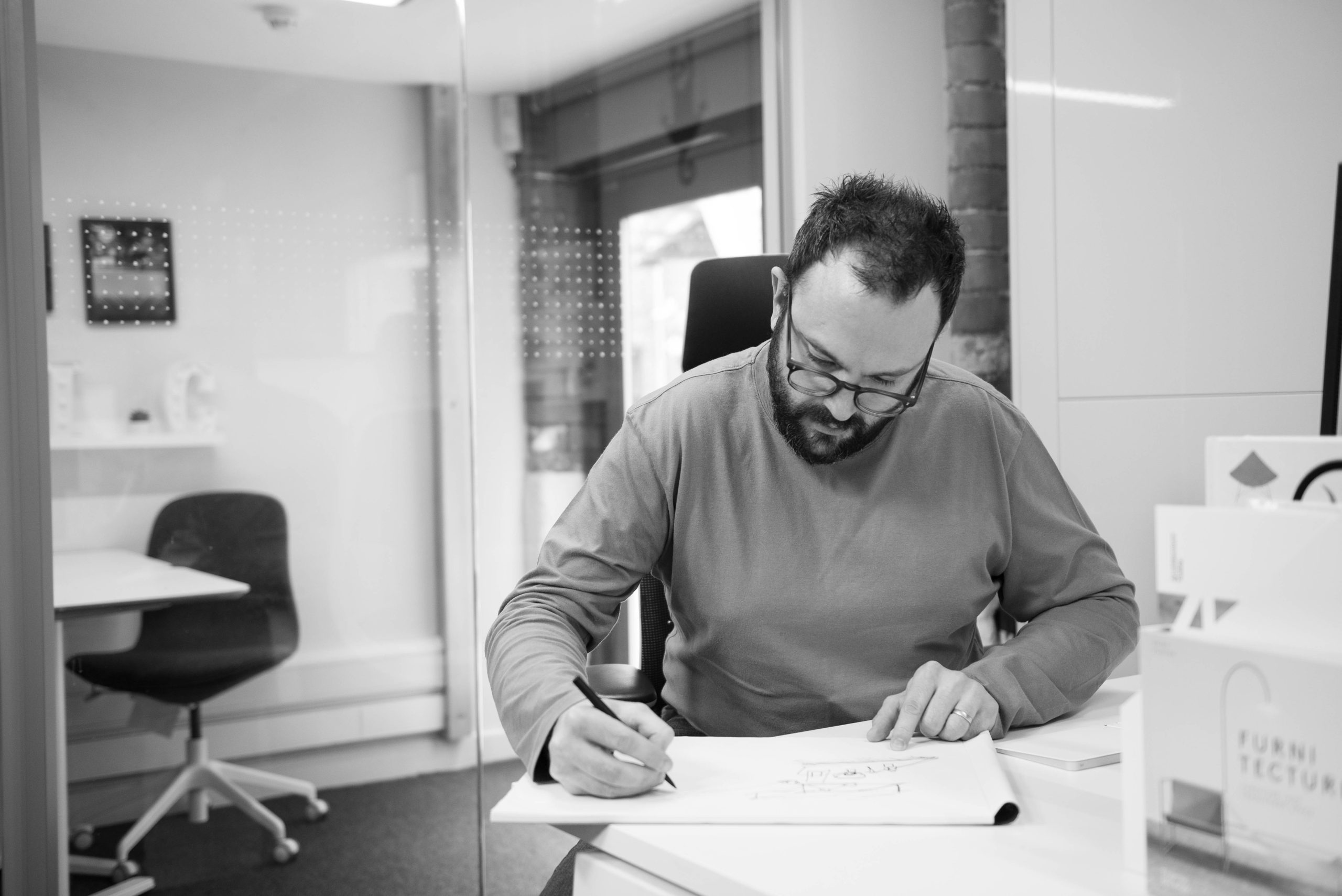 Mark scribbling designs down on paper
