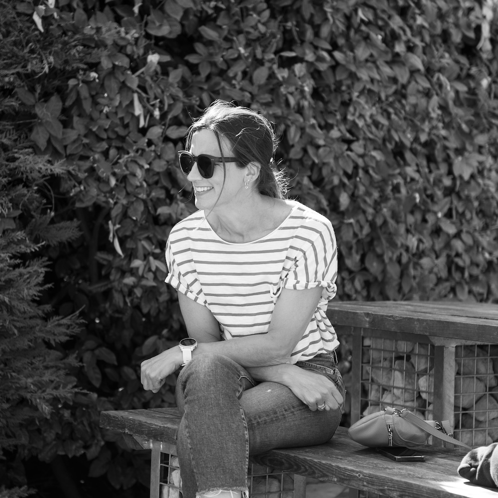 Sam Rowe laughing outside on a bench